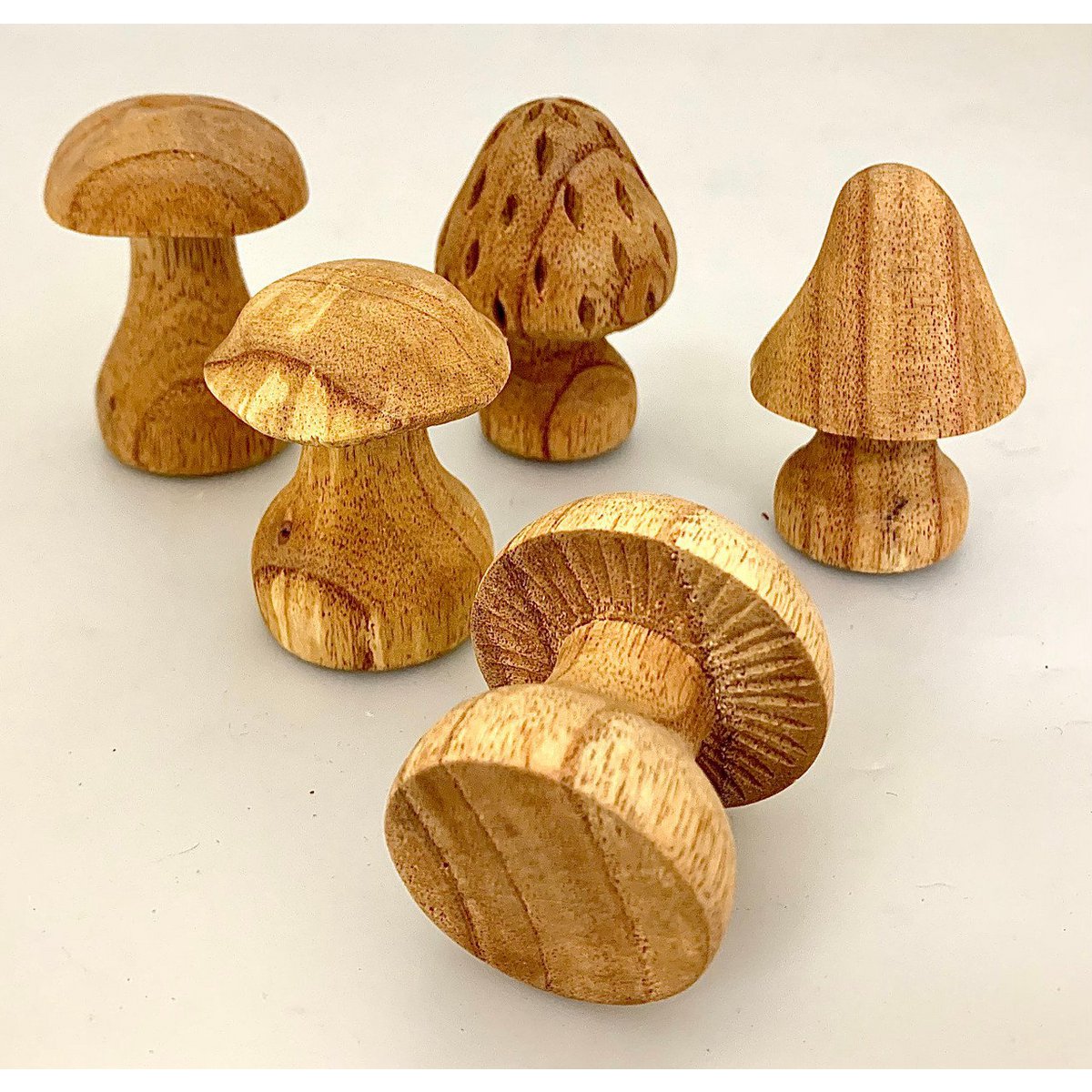 Set van 5 handgesneden houten paddenstoelen in verschillende vormen, perfect als decoratie of speelgoed in natuurlijke woonaccessoires categorie.