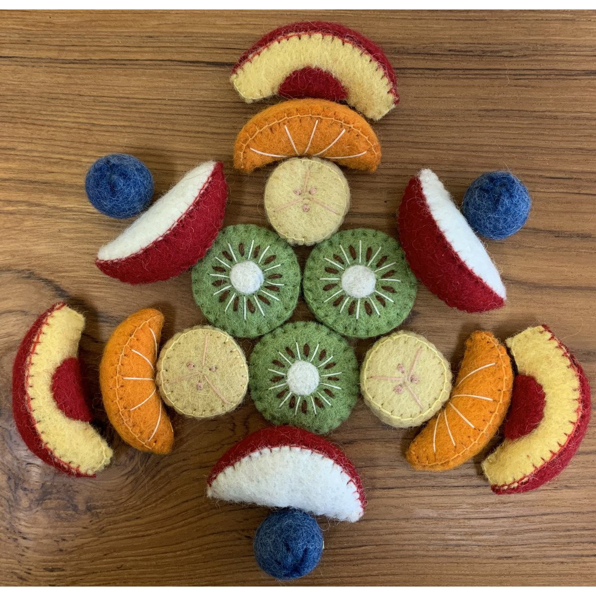 Vilten Fruit Salad/18pc netjes gerangschikt in cirkelvorm met realistische fruitdetails, ideaal voor educatief speelgoed of kinderkamerdecoratie.