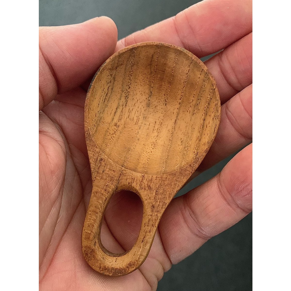 Close-up van een Moon Scoops/6pc houten lepel in hand, perfect voor nauwkeurige dosering van droge ingrediënten.