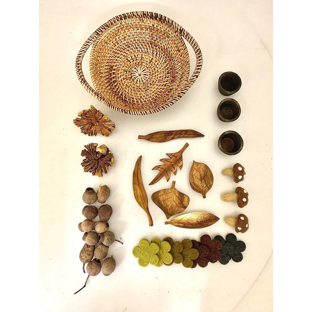 Nature Loose Parts Basket/35pc met houten bladeren, vilten bloemen, dennenappels en zaden op witte achtergrond. Ideaal voor sensorisch spel.
